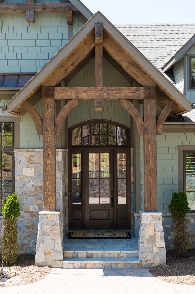 The timber framed front porch with tapered stone base provides a sense of arrival.