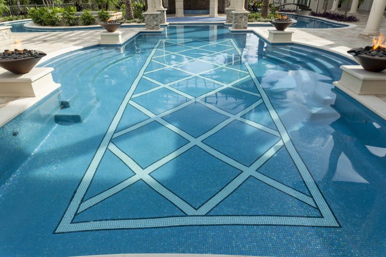 The uniquely shaped swimming pool is completely dressed in hand cut glass tile from Mexico including decorative in-pool detailing. Tiling by Mosaicist.