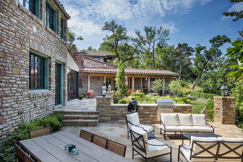 The view across the expanded patio with outdoor cooking area to the new upper patio and screen porch