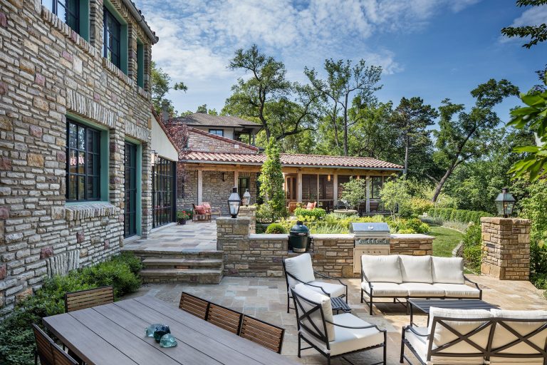 The view across the expanded patio with outdoor cooking area to the new upper patio and screen porch