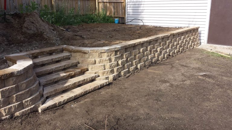 The wall is constructed. Now, we just need to finish back-filling and grade the area behind the wall.