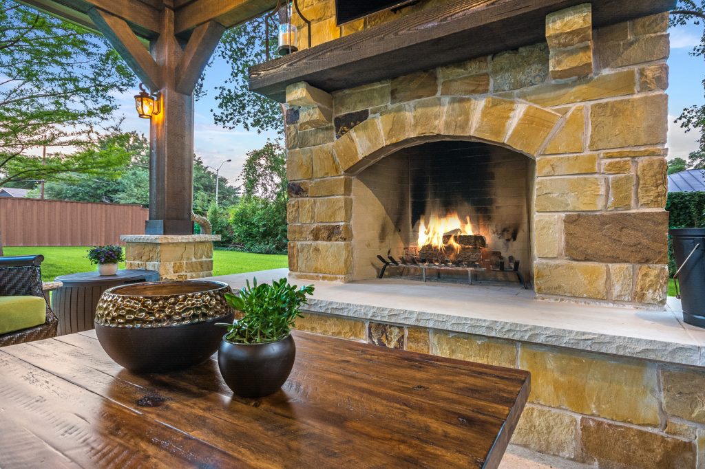 The wood-burning fireplace is constructed of the same stone and has a ledgestone hearth and cedar mantle. What a perfect place to cozy up and enjoy a cool evening outside.


Click Photography by TCP Custom Outdoor Living | Outdoor Kitchens | Backyard Design | Outdoor Living Spaces | Landscape Design