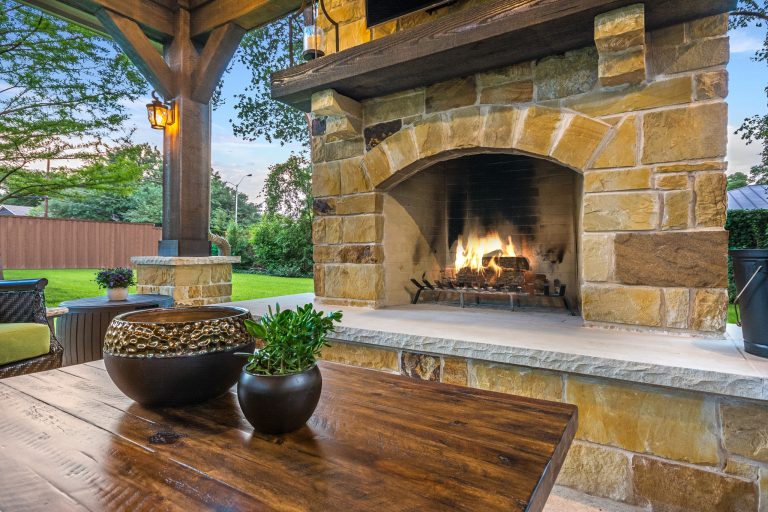 The wood-burning fireplace is constructed of the same stone and has a ledgestone hearth and cedar mantle. What a perfect place to cozy up and enjoy a cool evening outside.


Click Photography by TCP Custom Outdoor Living | Outdoor Kitchens | Backyard Design | Outdoor Living Spaces | Landscape Design