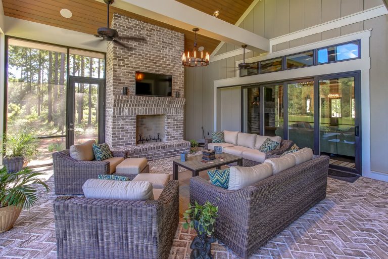 This Beautiful Screened Porch has a beautiful Brick Fireplace, brick floors and a two-story vaulted ceiling.