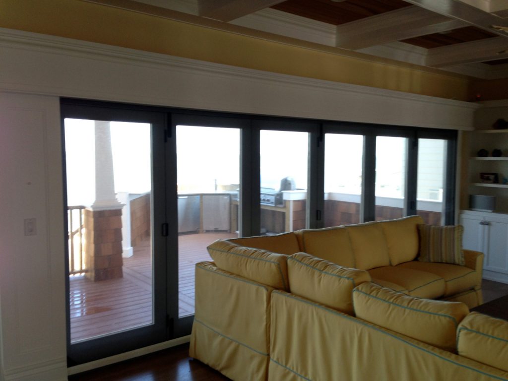 This Folding Glass door system folds away to allow for a seamless flow from the riving room to the deck. When needed a motorized Phantom Screen rolls down to provide insect and solar protection. by Garden State Retractables | Outdoor Kitchens | Backyard Design | Outdoor Living Spaces | Landscape Design