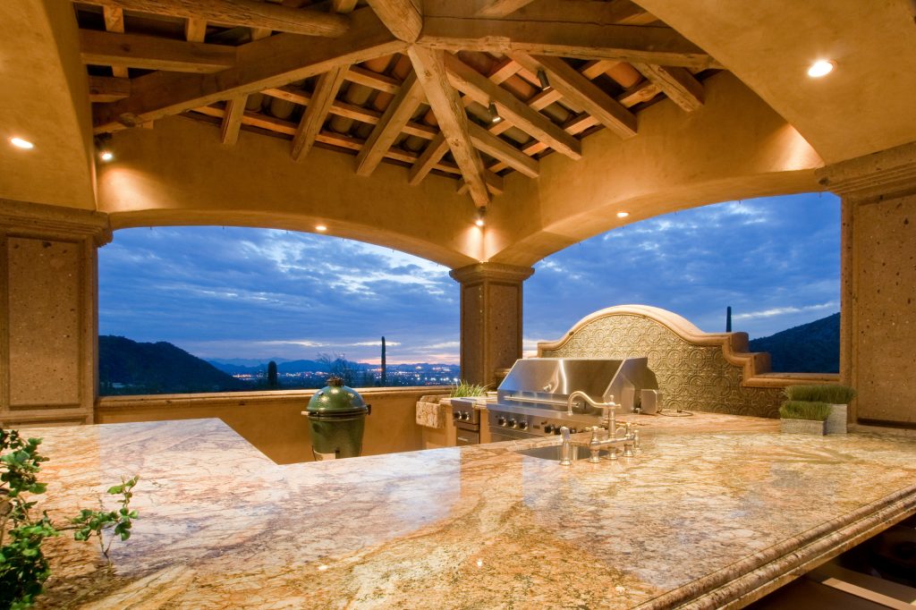 This Italian Villa outdoor grill sits under a custom-built ramada with exposed beam detailing.