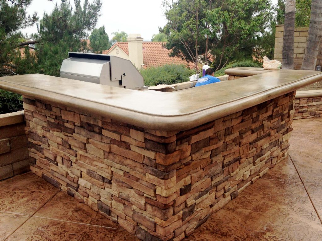 This Orange County Barbecue Island includes stacked stone siding and poured in place concrete counter tops. The barbecue is an American Made grill. The outdoor kitchen also includes a mini fridge. by TRU Landscape Services | Outdoor Kitchens | Backyard Design | Outdoor Living Spaces | Landscape Design