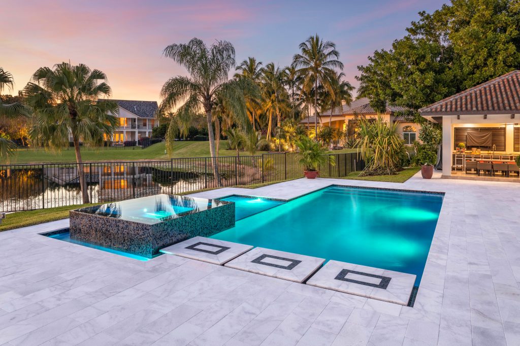This amazing custom pool and wet edge spa in Weston is the perfect outdoor getaway! Complete with custom stepping stones, sun shelf, and LED bubblers, this project is sure to please family and guests!