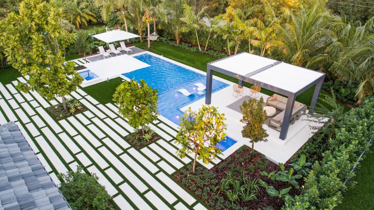 This amazing custom pool with stepping pavers leading to an outdoor pergola, vanishing edge spa, sun shelf with LED bubblers and custom landscaping pattern is truly a backyard oasis!