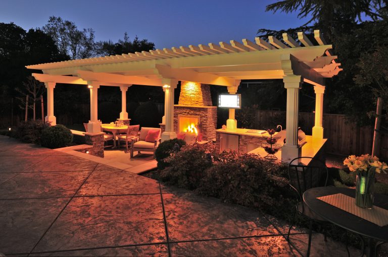 This cabana has a kitchen island, fireplace, TV, and outdoor lighting; a space that is ready for fun both daytime and night. Tom Minczeski, photographer