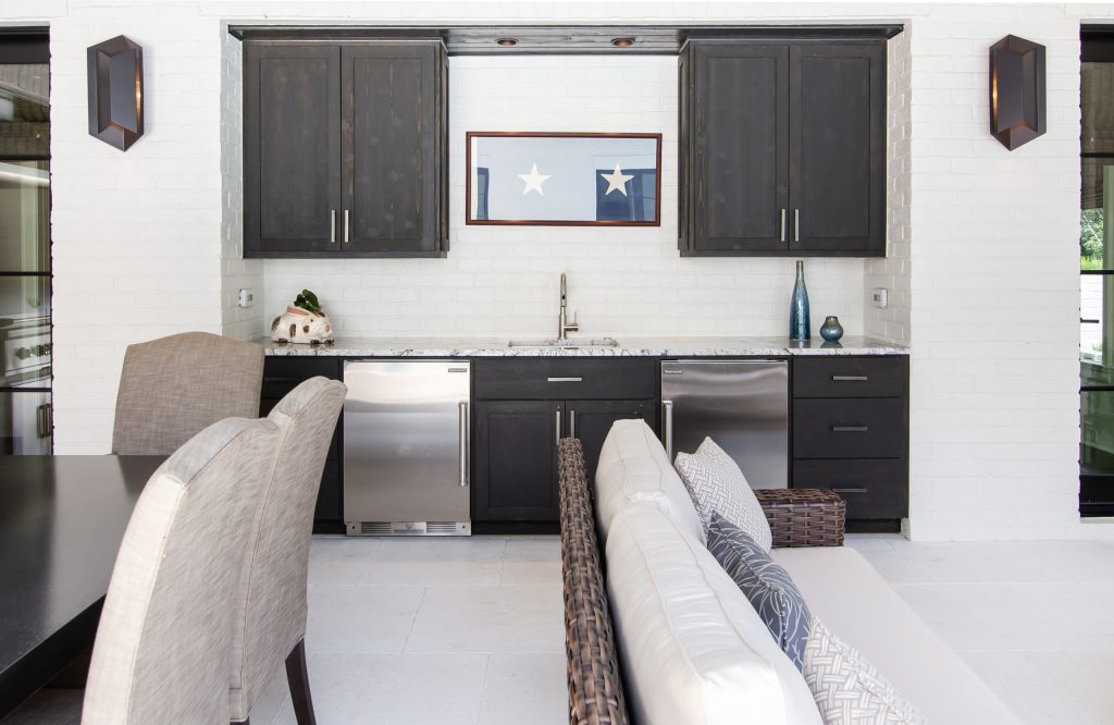 This covered outdoor living space is the perfect poolside hangout spot. The custom outdoor cabinets and built-in appliances give this space the fuctionality it would otherwise lack.