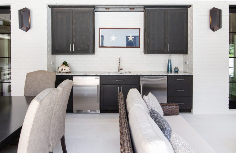 This covered outdoor living space is the perfect poolside hangout spot. The custom outdoor cabinets and built-in appliances give this space the fuctionality it would otherwise lack.