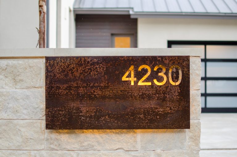 This custom back lit metal house numbers provides great contrast to the clean exterior finish of the house.