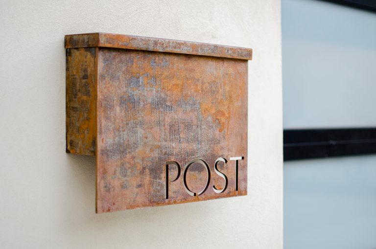 This custom metal mailbox provides great contrast to the clean exterior finish of the house.