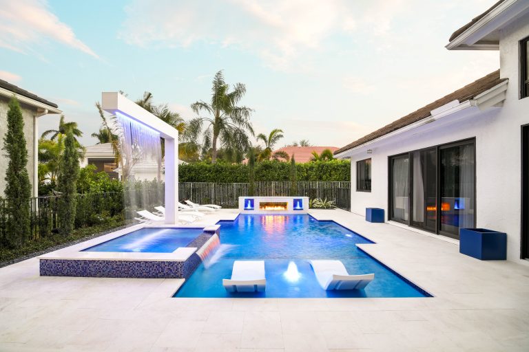This custom pool and spa have everything a backyard needs. The custom pergola over the spa rains water to keep you warm. There is also a raised wall with 2 bubblers and a fire feature.