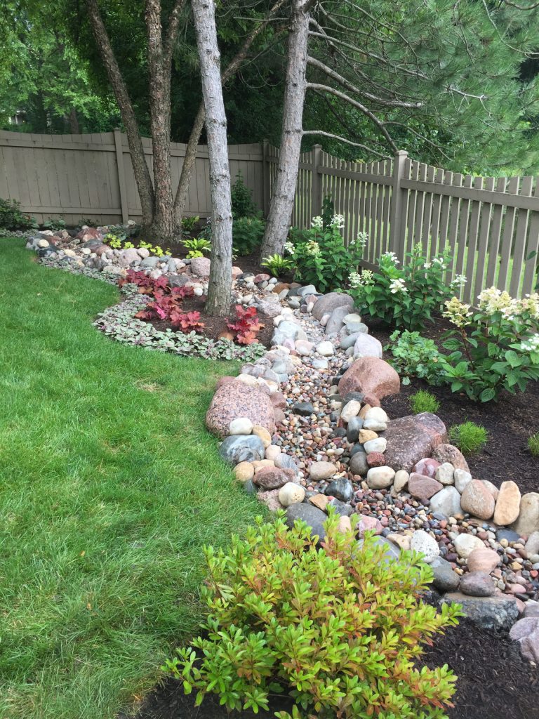 This dry river bed not only add interest to the back yard, it helps retain the grade. Lots of four season planting interest make this fun to look at form the window any time of the year.