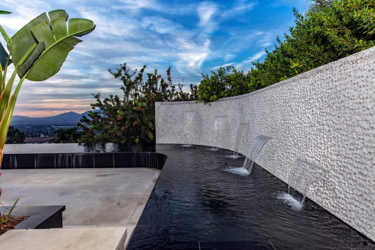 This is an example of a contemporary backyard water fountain landscape in Los Angeles.