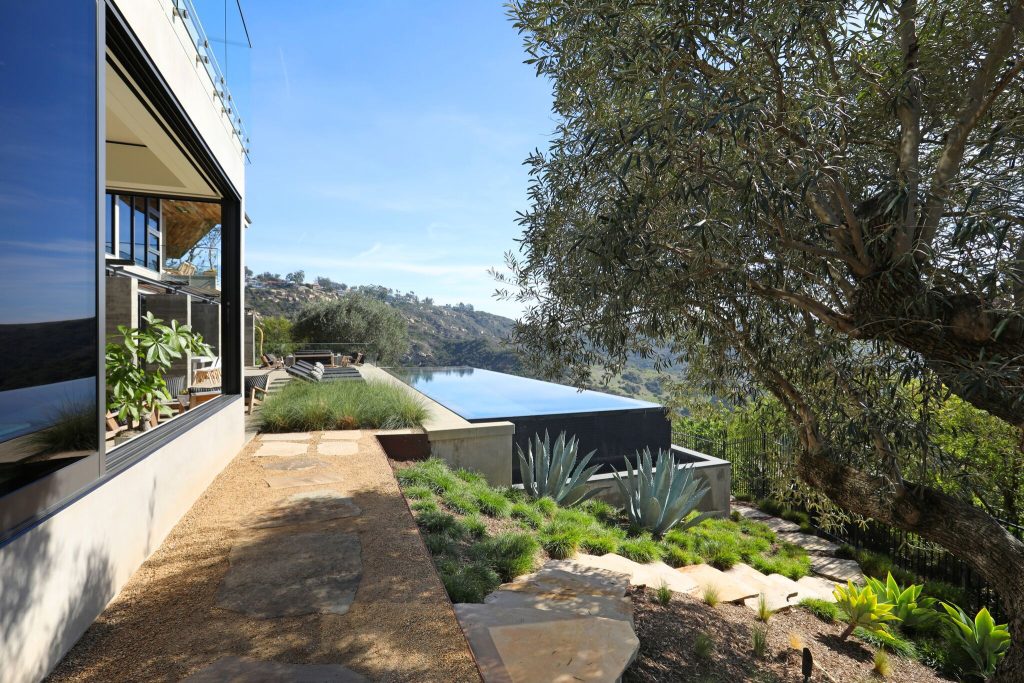 This is an example of a huge contemporary partial sun backyard stone landscaping in Orange County for spring.