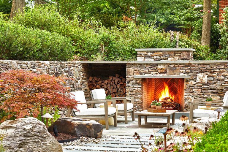 This is an example of a large contemporary full sun backyard stone landscaping in DC Metro with a fireplace for summer.