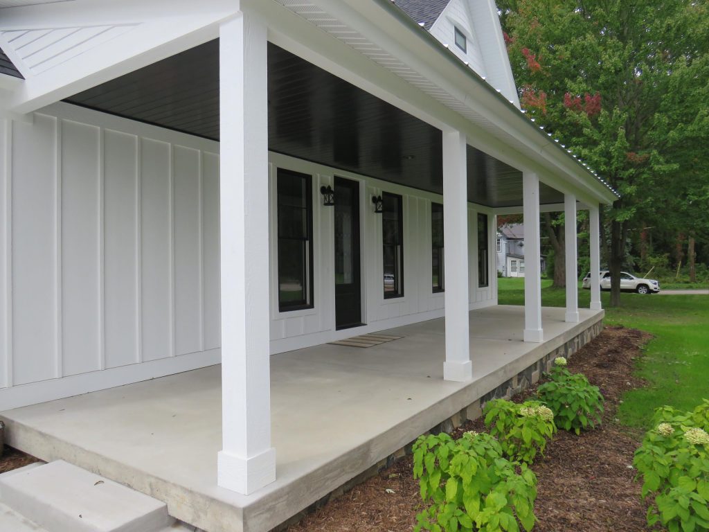 This is an example of a large country concrete front porch design in Grand Rapids with a roof extension. by Beth Gilbert Interiors | Outdoor Photos | Porch | Landscaping | Landscape Design | Outdoor Living Space | Porch Design Ideas | Outdoor Living Space Ideas | Backyard Design