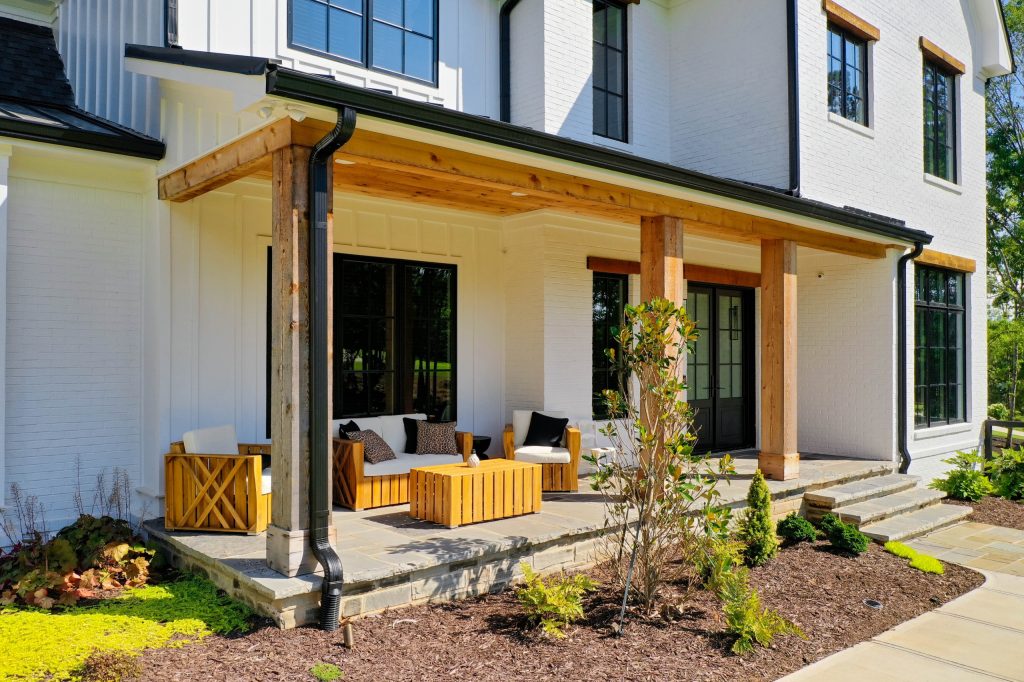 This is an example of a large country stone front porch design in Atlanta with a roof extension. by Studio Design Elements | Outdoor Photos | Porch | Landscaping | Landscape Design | Outdoor Living Space | Porch Design Ideas | Outdoor Living Space Ideas | Backyard Design