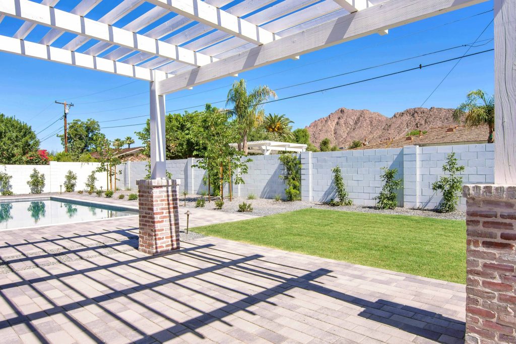 This is an example of a large craftsman concrete paver porch design in Phoenix with a pergola.