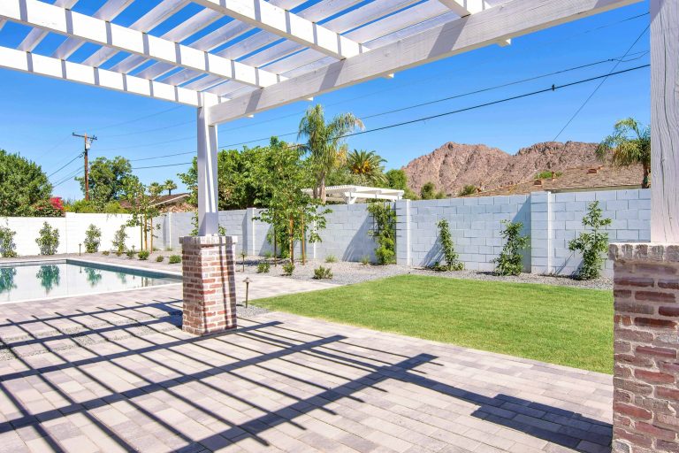 This is an example of a large craftsman concrete paver porch design in Phoenix with a pergola.