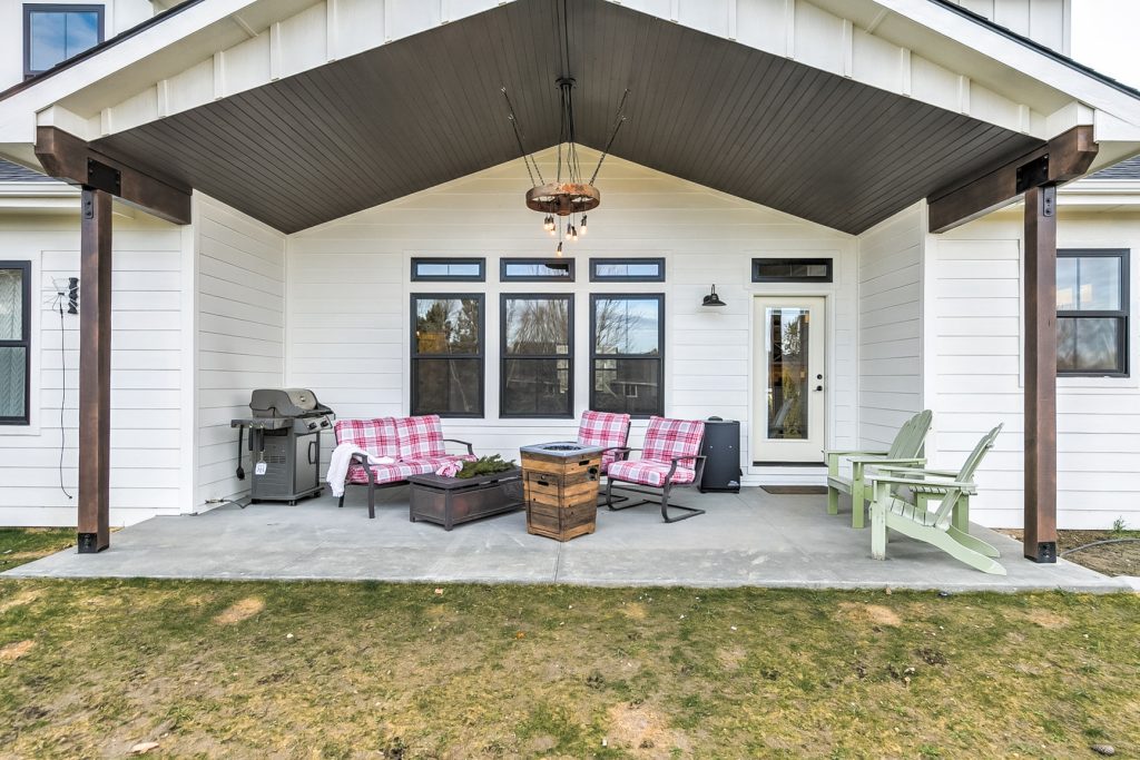 This is an example of a large farmhouse concrete back porch design in Boise with a roof extension. by Schneider Custom Homes | Outdoor Photos | Porch | Landscaping | Landscape Design | Outdoor Living Space | Porch Design Ideas | Outdoor Living Space Ideas | Backyard Design
