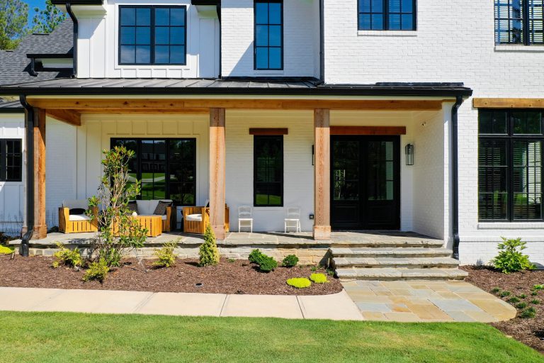 This is an example of a large farmhouse stone front porch design in Atlanta with a roof extension. by Studio Design Elements | Outdoor Photos | Porch | Landscaping | Landscape Design | Outdoor Living Space | Porch Design Ideas | Outdoor Living Space Ideas | Backyard Design