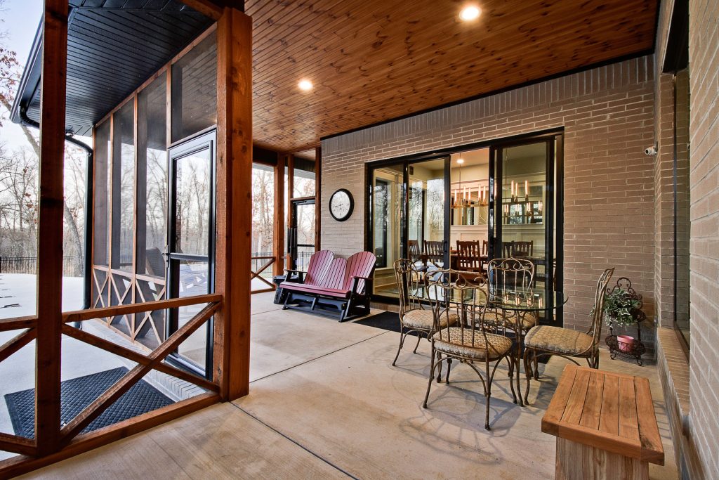 This is an example of a large modern concrete screened-in back porch design in Other with a roof extension. by Celtic Custom Homes | Outdoor Photos | Porch | Landscaping | Landscape Design | Outdoor Living Space | Porch Design Ideas | Outdoor Living Space Ideas | Backyard Design