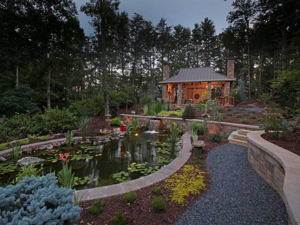 This is an example of a large rustic backyard stone water fountain landscape in Atlanta.