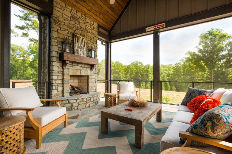 This is an example of a large rustic stone screened-in back porch design in Other with a roof extension. by The Cottage Group | Outdoor Photos | Porch | Landscaping | Landscape Design | Outdoor Living Space | Porch Design Ideas | Outdoor Living Space Ideas | Backyard Design