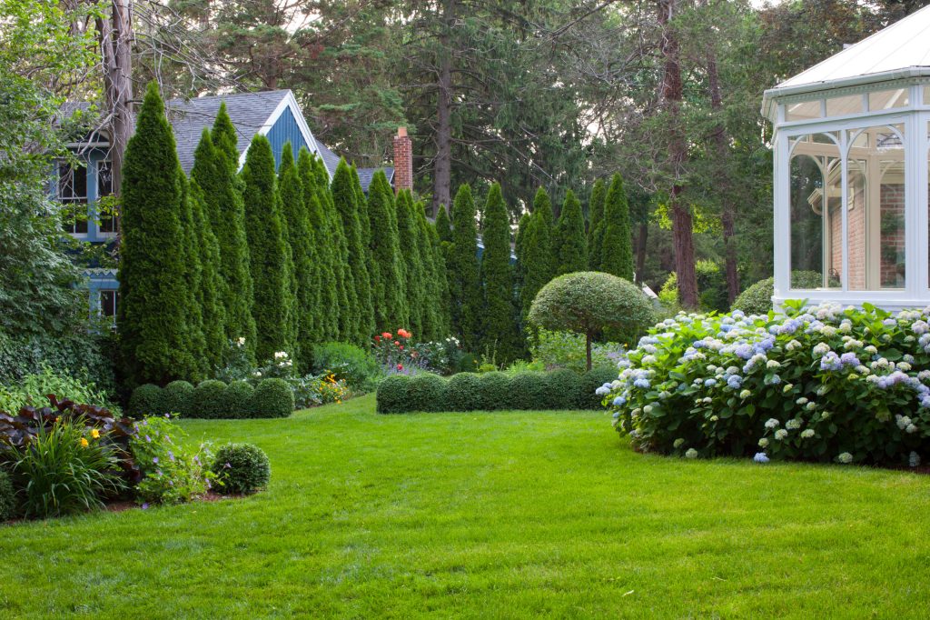 This is an example of a large traditional partial sun backyard formal garden in New York.