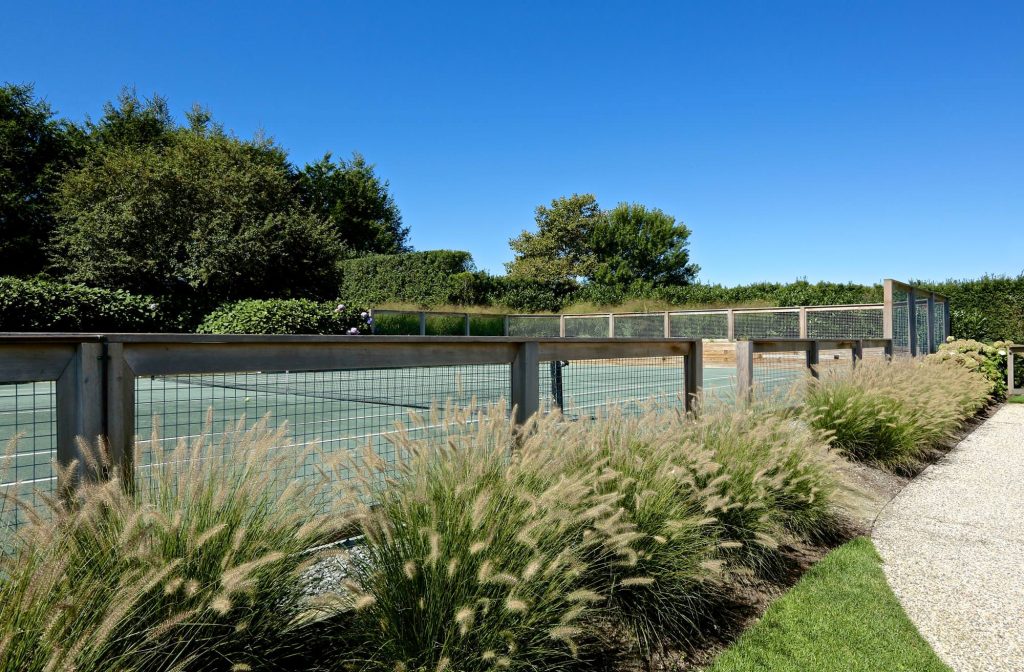 This is an example of a large traditional partial sun backyard gravel landscaping in New York.