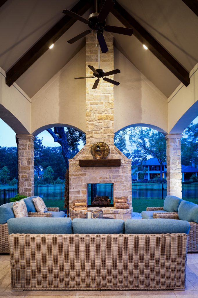 This is an example of a large traditional stone porch design in Houston with a roof extension.