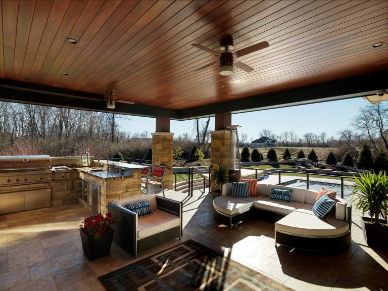 This is an example of a large traditional stone porch design in Other with a roof extension.