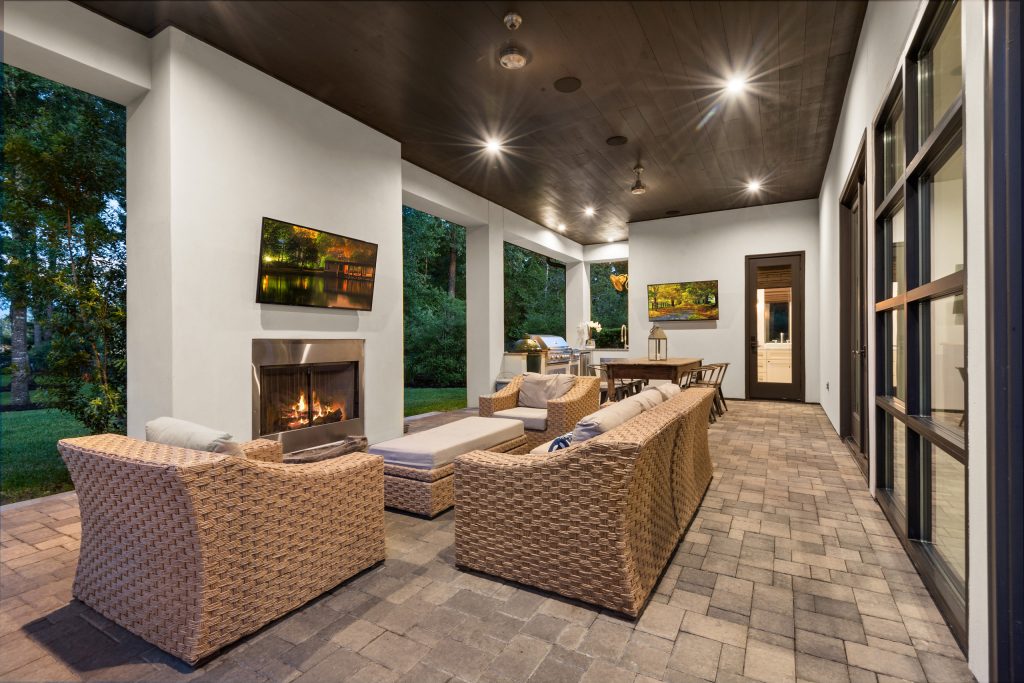 This is an example of a large transitional stone back porch design in Houston with a fireplace and a roof extension. by Wyrick Residential Design | Outdoor Photos | Porch | Landscaping | Landscape Design | Outdoor Living Space | Porch Design Ideas | Outdoor Living Space Ideas | Backyard Design