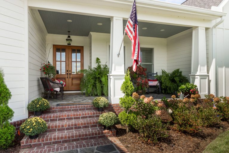 This is an example of a mid-sized farmhouse stone front porch design in Nashville with a roof extension. by J Taylor Designs | Outdoor Photos | Porch | Landscaping | Landscape Design | Outdoor Living Space | Porch Design Ideas | Outdoor Living Space Ideas | Backyard Design