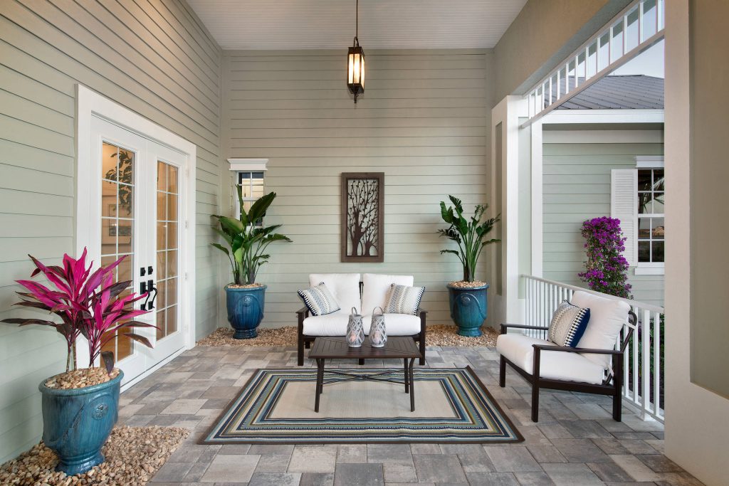 This is an example of a mid-sized tropical stone porch design in Miami with a roof extension. by Norris Furniture & Interiors | Outdoor Photos | Porch | Landscaping | Landscape Design | Outdoor Living Space | Porch Design Ideas | Outdoor Living Space Ideas | Backyard Design