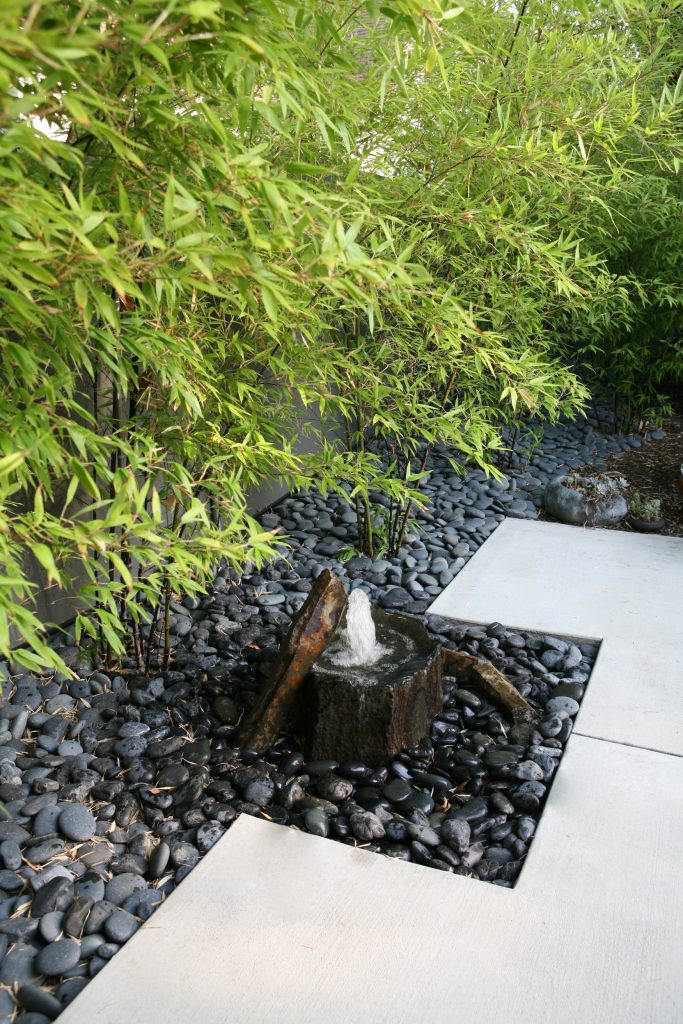 This is an example of a mid-sized asian full sun backyard stone landscaping in Orange County.