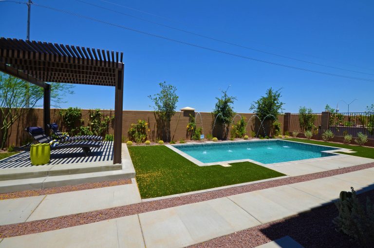 This is an example of a mid-sized contemporary full sun backyard concrete paver landscaping in Phoenix for summer.