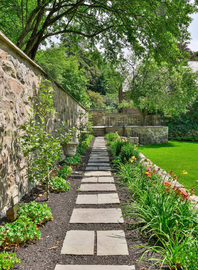 This is an example of a mid-sized traditional partial sun backyard stone and stone fence garden path in Boston.
