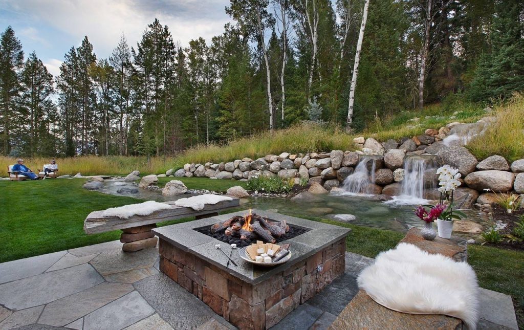This is an example of a rustic backyard landscaping in Other with a fire pit.