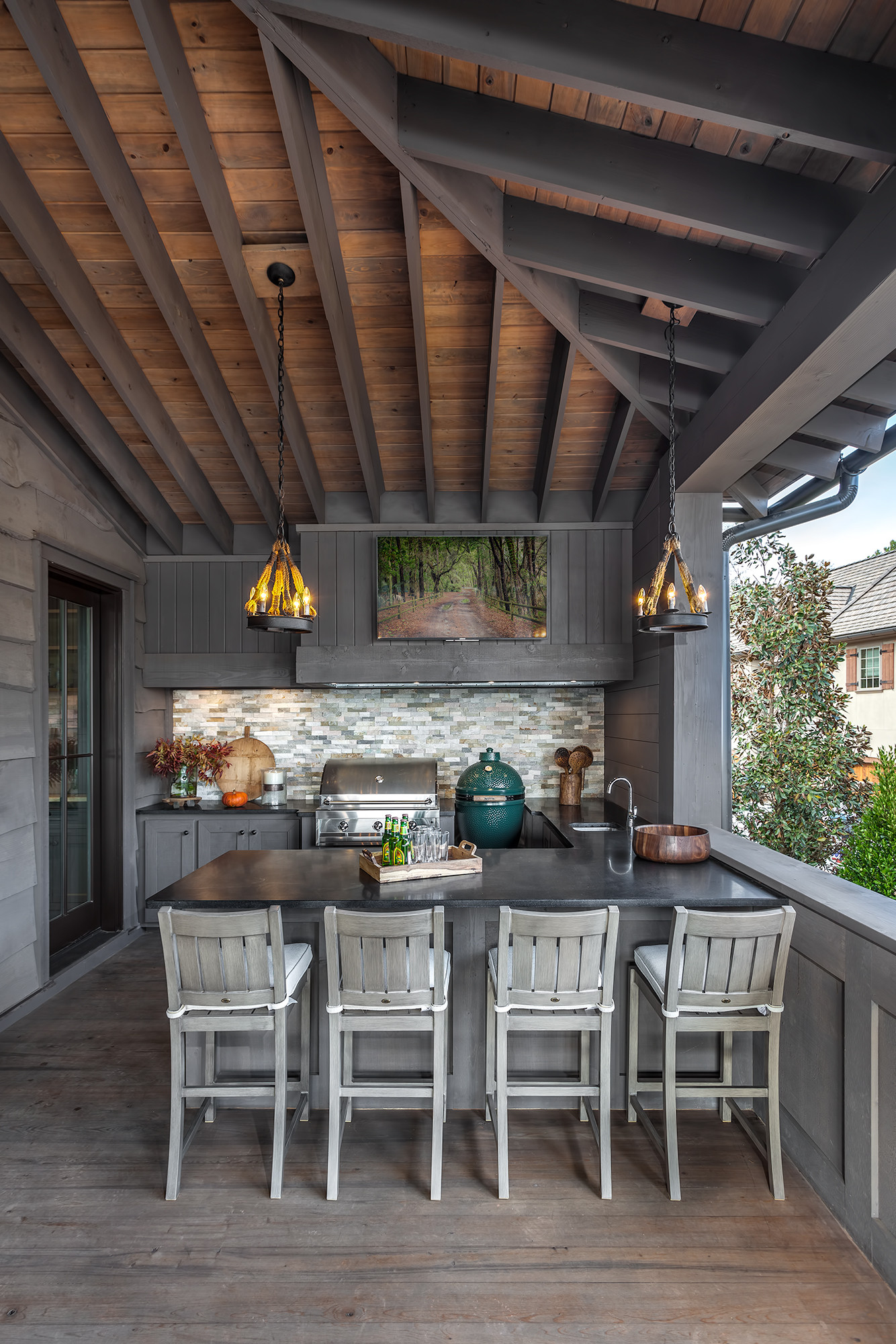 This is an example of a rustic wood railing outdoor kitchen porch design in Charleston with decking and a roof extension.