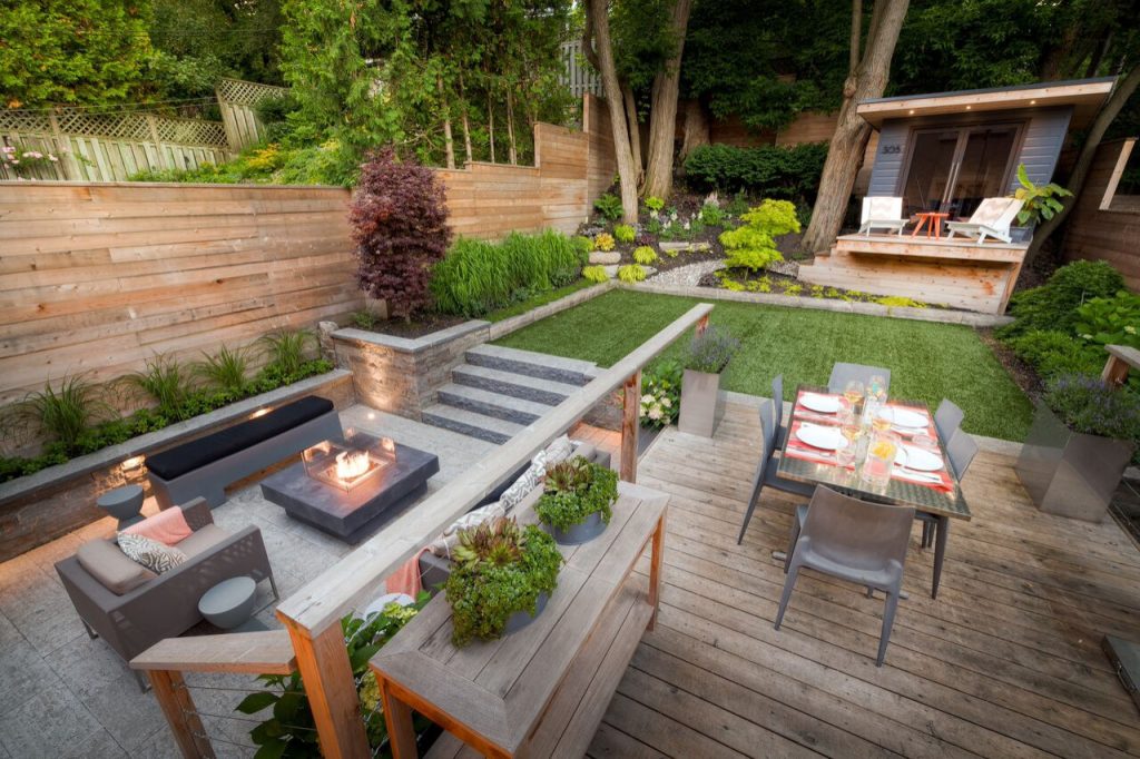 This is an example of a small contemporary backyard stone landscaping in Toronto with a fire pit.