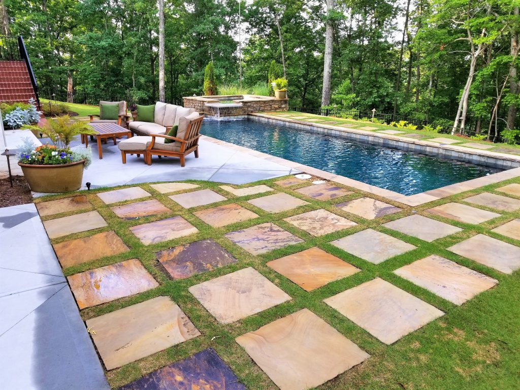 This is one of our custom rectangular pools with stone and grass terraces and raised stacked stone spa.