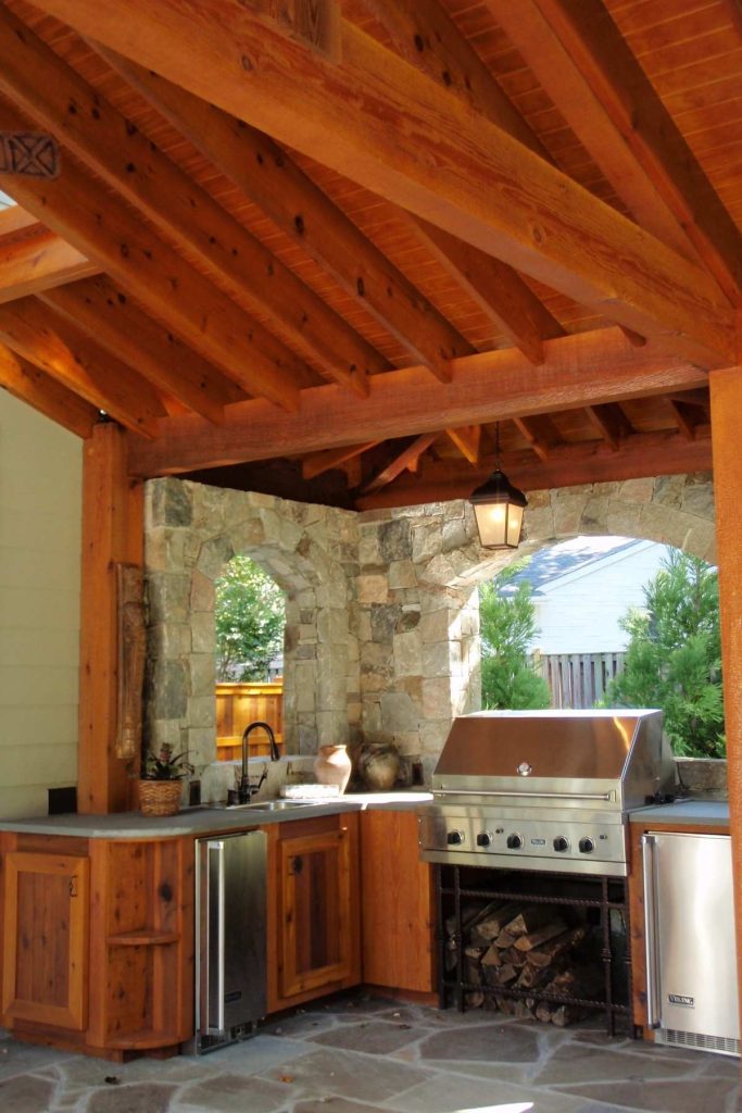 This magnificent outdoor kitchen brings the best of modern conveniences to the great outdoors. The field stone walls and cedar roof enclose the flagstone patio and its array of stainless steel appliances.