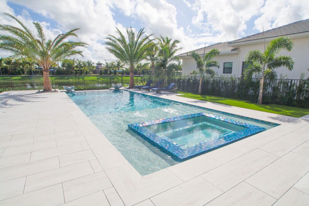 This masterpiece in Delray Beach, Florida has a modern infinity edge, custom sunken spa with sunshelf, and Van Kirk & Sons Pools & Spas custom made water bowls. The pool has an amazing, one of a kind look and feel!