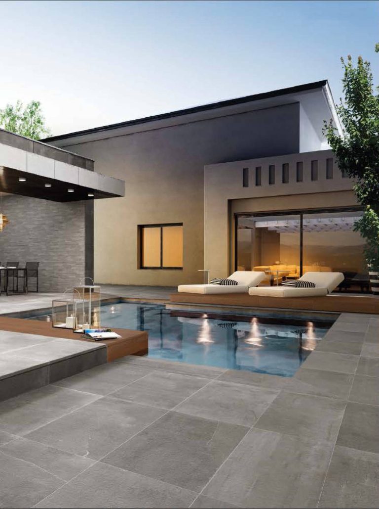 This modern pool has a stone look porcelain tile called Stoneone Silver Prestige Brown on the floors and Stoneone Dark and Stoneone Silver Muretto on the walls.
