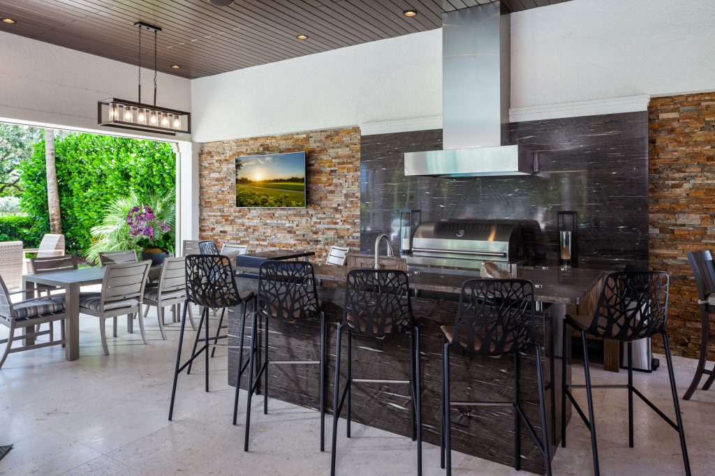 This outdoor kitchen remodel turned out fabulous. Custom raised bar top with impeccable stone installation. Custom hood installation. Removed existing openings with roll down screens. by Select Development Group | Outdoor Kitchens | Backyard Design | Outdoor Living Spaces | Landscape Design